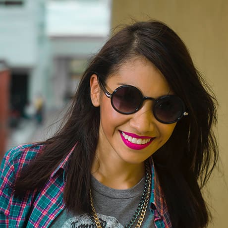 A woman in a plaid shirt is at home.